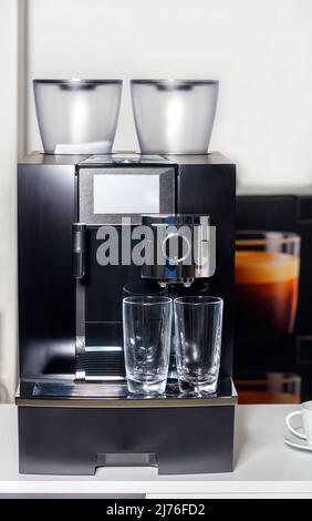 Two empty glass cups stand coffee of machine stand. Copy space. Stock Photo