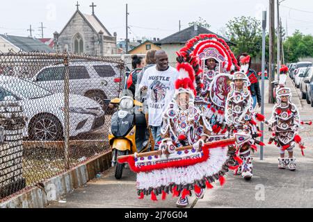 NEW ORLEANS, LA, USA - MARCH 17, 2019: Costumed young and old Mardi Gras Indians walk past St. Joseph Cemetery to the LaSalle Street parade route Stock Photo