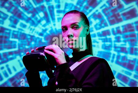 Serious beautiful young woman putting on VR goggles while sinking into virtual reality Stock Photo