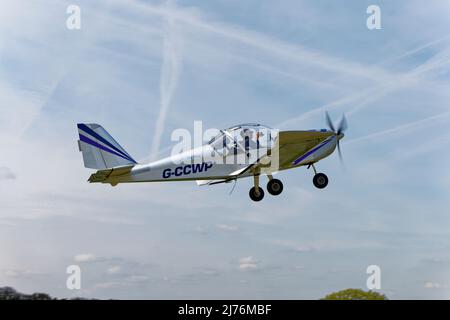 Lovely clean silver Eurostar EV-97 microlight aircraft G-CCWP departs Popham airfield in Hampshire England after attending the annual aircraft fly-in Stock Photo