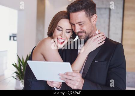 Happy young white couple shopping together by digital tablet Stock Photo