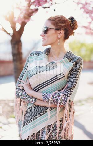Young balanced redhead woman enjoying springtime sunshine in park Stock Photo