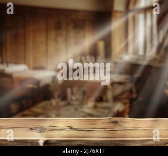 Old wooden table top and blurred rural cafe interior at the background. Empty table and free space for any product placement and advertising. Stock Photo