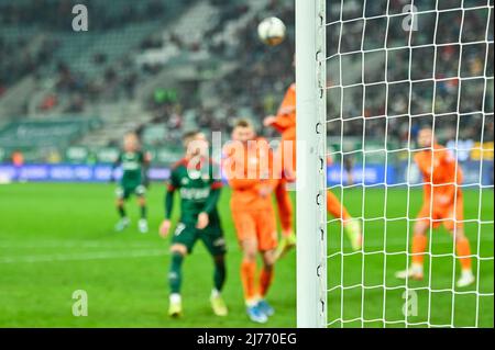 Soccer goal post and soccer match in the background Stock Photo