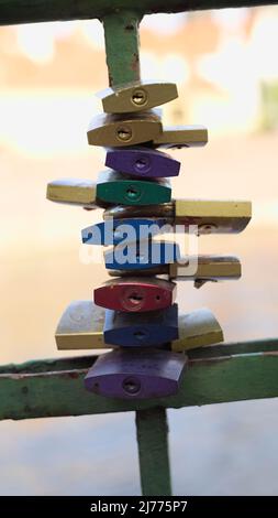 Colorful padlocks pinned to a park bridge Stock Photo