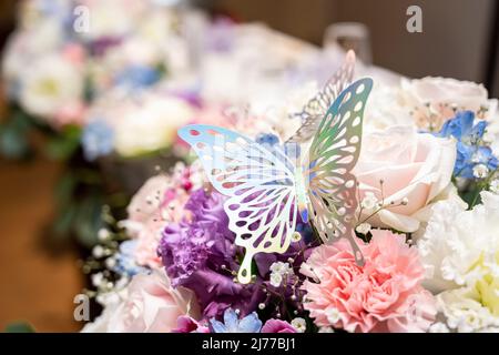 A metal butterfly is stopped on the flower displayed in Takasago Stock Photo