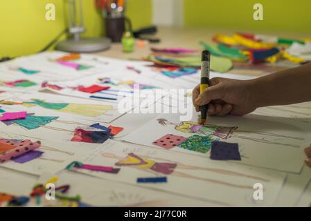 Latin fashion designer sketching on her desk using markers Stock Photo