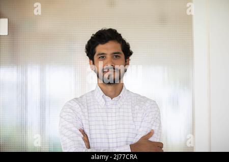 young man working as manager in an office in front off a glass door Stock Photo