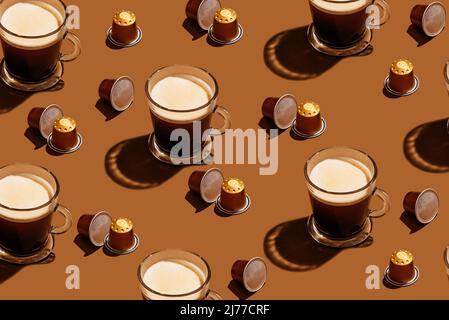 coffee in capsules and in a cup on a brown background Stock Photo