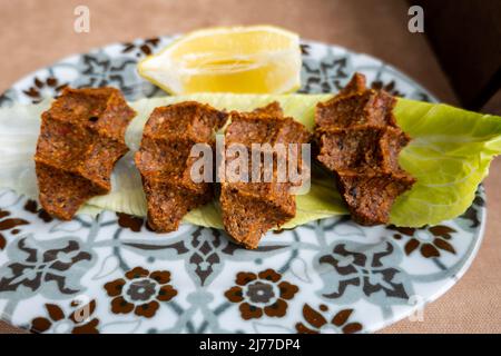 Cig Kofte (raw meatball in Turkish) with lettuce, traditional Turkish cuisine popular in Turkey Stock Photo