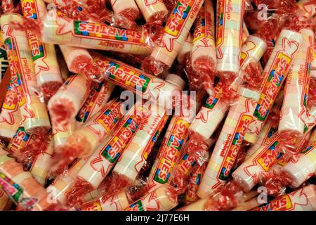 The United States version of Smarties, a round tablet candy produced by Smarties Candy Company, formerly known as Ce De Candy Inc.; close-up rolls. Stock Photo