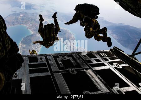 Members of Greek Special Forces (SOF) prepare for Exercise Orion as they jump from the ramp of a Greek Air Force C-130 aircraft during airborne operation over a coastal area near Elefsina, Greece, March 30, 2022. Exercise Orion reinforces Greece as a regional SOF leader, enhances interoperability across multiple domains, and strengthens relationships with NATO and non-NATO partners. The exercise focuses on highlighting operational capabilities, international collaborations and conventional and hybrid warfare training. (U.S. Army photo by Sgt. Hannah Hawkins) Stock Photo