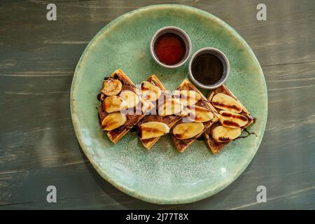 Belgian waffles with banana and chocolate topping Stock Photo