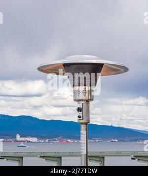 Round Mushroom Propane Patio Heater in outdoor restaurant patio. Gas heater for patio-Vancouver BC. Street photo, travel photo, selective focus, nobod Stock Photo