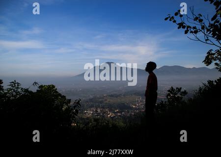 Sumedang, West Java, Indonesia. 7th May, 2022. A child is seen enjoying the view of Manglayang Mountain on May 7, 2022, at Mount Batu Tanjungsari, Sumedang Regency, Indonesia. Mount Batu Tanjungsari is one of the tourist destinations for people to spend the Eid al-Fitr holiday 1443 H with their families. (Credit Image: © Algi Febri Sugita/ZUMA Press Wire) Stock Photo