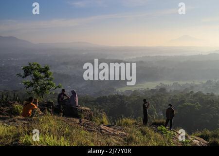 Sumedang, West Java, Indonesia. 7th May, 2022. People took a picture with the backdrop of natural scenery on May 7, 2022 at Mount Batu Tanjungsari, Sumedang Regency, Indonesia. Mount Batu Tanjungsari is one of the tourist destinations for people to spend the Eid al-Fitr holiday 1443 H with their families. (Credit Image: © Algi Febri Sugita/ZUMA Press Wire) Stock Photo