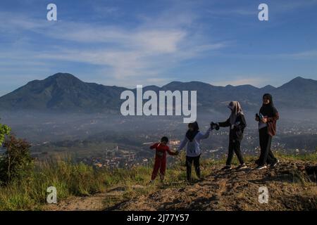 Sumedang, West Java, Indonesia. 7th May, 2022. Women took a picture with the backdrop of natural scenery on May 7, 2022 at Mount Batu Tanjungsari, Sumedang Regency, Indonesia. Mount Batu Tanjungsari is one of the tourist destinations for people to spend the Eid al-Fitr holiday 1443 H with their families. (Credit Image: © Algi Febri Sugita/ZUMA Press Wire) Stock Photo
