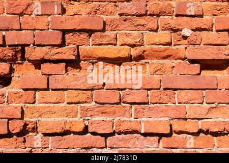 A fragment of an old red brick wall on a sunny day Stock Photo