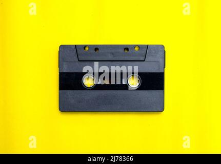 Old compact cassette tape on yellow background Stock Photo