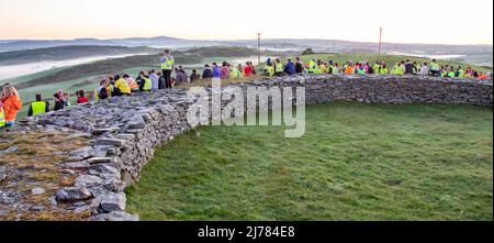 Crowds watching dawn sunrise after darkness into light walk. Knockdrum stone ring fort, West Cork, Ireland Stock Photo