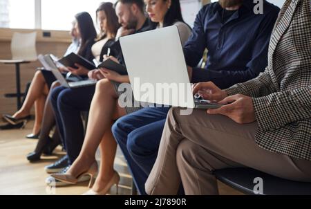 Business people or corporate employees sitting in office and working on laptop computers Stock Photo