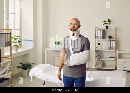 Portrait of sad man with neck brace and sling on his arm who was injured after car accident. Stock Photo