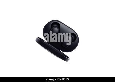 Wireless black bluetooth earphones with contactless charging isolated on a white background. Top view Stock Photo