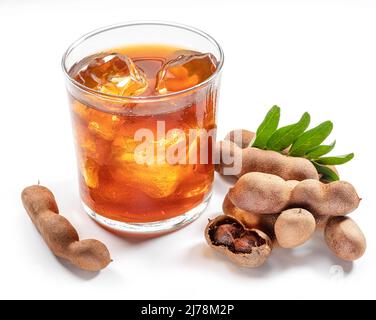 Glass of cool refreshing tamarind drink and some tamarind fruit on white background. Stock Photo
