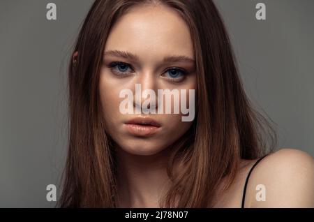 Portrait beautiful model posing in studio over grey background. Caucasian portrait woman. Stock Photo