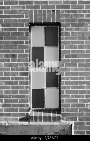 Bohemian brick building with an interesting alternating pane window in black and white. Stock Photo