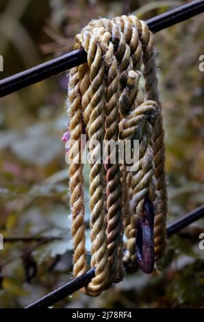 fibrous rope wrapped around metal fence bars Stock Photo