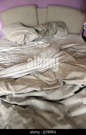 pulled back sheets on unmade empty double bed Stock Photo
