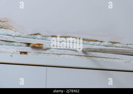 Master installs the interior door using polyurethane foam to mounting Stock Photo
