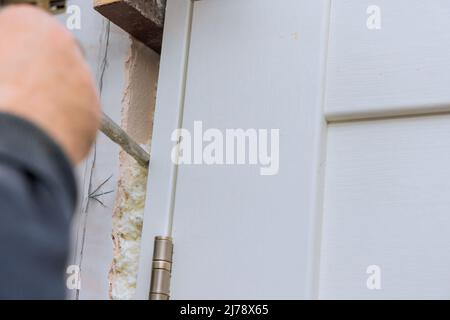 Worker install door, using polyurethane foam to mounting it between at wall Stock Photo