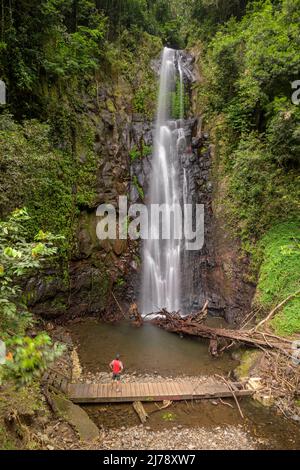 Man standing in front of the San Nicolau waterfall. Stock Photo