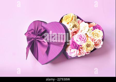Heart shape gift box and bouquet. Flowers a gift in the shape of a heart. Roses in a box heart on pink background Stock Photo