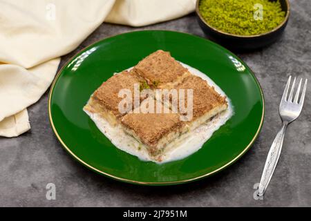 Cold baklava. Baklava with milk on a dark background. Mediterranean cuisine delicacies. Close-up. Local name soguk baklava Stock Photo