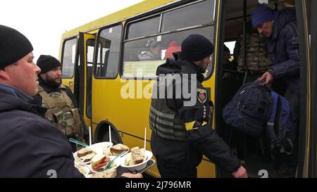 KYIV, UKRAINE - MARCH 9: Evacuees from Irpin and Vorzel receive hot drinks and food at an emergency camp set up for evacuated residents from active combat areas on the outskirts of Kyiv, as Russia's invasion of Ukraine continues on 9 March 2022 in Kyiv, Ukraine. Russia began a military invasion of Ukraine after Russia's parliament approved treaties with two breakaway regions in eastern Ukraine. It is the largest military conflict in Europe since World War II. Stock Photo