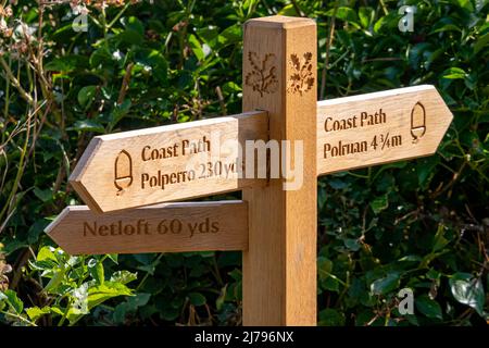 A National Trust Sign Post for the South West Coast Path pictured in Polperro, Cornwall, UK. Stock Photo