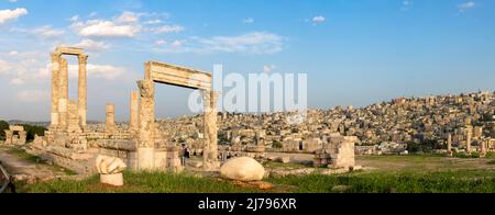 Amman, Jordan its Roman ruins in the middle of the ancient citadel park in the city center. Sunset over Amman skyline and historic city center with be Stock Photo