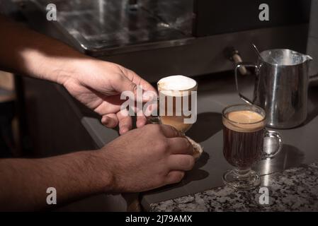 Preparing two coffees on a bar counter. Man hands. Horizontal. Color. Stock Photo
