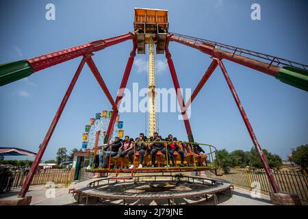 May 6, 2022, Khan Younis, Gaza Strip, Palestine: Gaza Strip, Palestine. May 4, 2022: Palestinians have fun at an amusement park during the Eid al-Fitr holidays in Khan Yunis, in the southern Gaza Strip. Relative calm is felt in Gaza at the end of the holy month of Ramadan despite the tension between Israeli forces and Palestinians during the Muslim holy month especially at Al-Aqsa compound in Jerusalem (Credit Image: © Yousef Mohammad/IMAGESLIVE via ZUMA Press Wire) Stock Photo