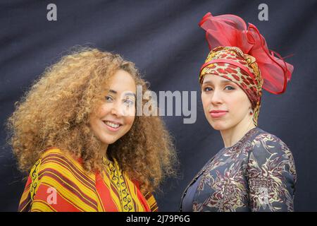 London, UK, 7th May 2022. A performer with group Arfoud Brothers and Sisters (left) and fashion designer Badra Cherfi, Creative Director at Bophonysse fashion, both take part in the official programme to celebrate Eid.  Eid in the Square, a festival to that celebrates Eid al-Fitr and the end of Ramadan, returns for its 17th year to showcase the  Islamic inspired art and culture  with performances food and stalls from across the world lining the Square. Stock Photo