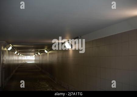 Long tunnel. Light at end of tunnel. Light in hallway. Architectures were underground. Pedestrian crossing under highway. Stock Photo