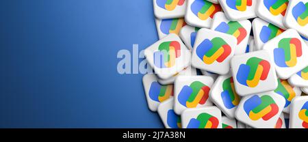 Logos of the Google Pay (Google Wallet plus Android Pay) service on a heap on a table. Copy space. Web banner format. Stock Photo