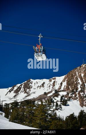 Gondola lift going up at the Snowbasin Ski Resort in Utah. Beautiful landscape of rocky mountains around. Stock Photo