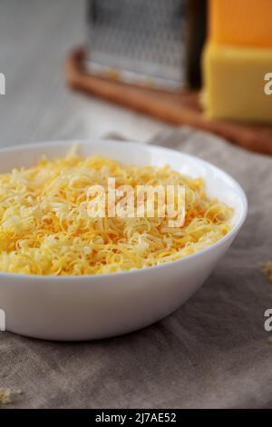 Shredded Mexican Cheese Mix in a White Bowl, side view. Stock Photo