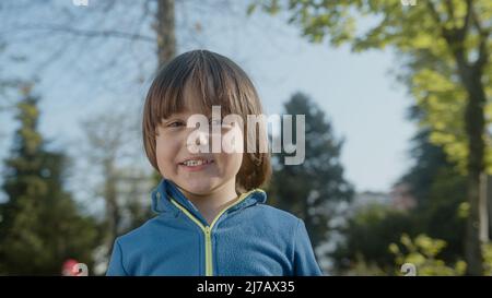 Boy posing portrait looking at camera and smiling cheerfully Stock Photo
