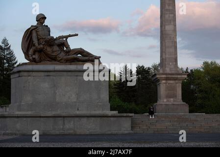 May 7, 2022, Warsaw, Warsaw, Poland: A woman sits next to a sculpture at the Soviet soldiers cemetery on May 7, 2022 in Warsaw, Poland. The Soviet Military Cemetery was built between 1949 and 1950 and it contains the ashes of over 21.000 Soviet soldiers from the 1st Byelorussian Front who died either in battle or as a result of injuries sustained during the battle to liberate Warsaw against armies of the Third Reich in 1944-1945. (Credit Image: © Aleksander Kalka/ZUMA Press Wire) Stock Photo