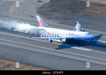 China Airlines Cargo Boeing 747 freighter aircraft hard landing. Large cargo airplane 747-400F aerial view. Plane 747F arrival. Landing gear smoke. Stock Photo